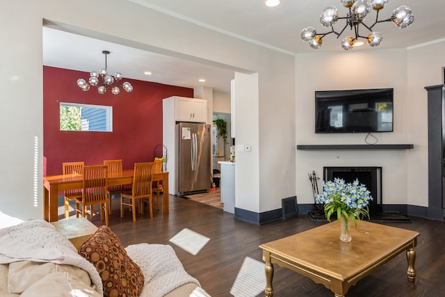 living room with crown molding, a notable chandelier, and dark hardwood / wood-style flooring