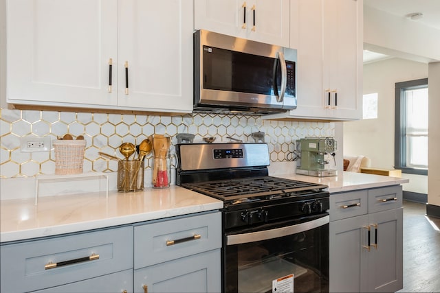 kitchen featuring white cabinets, light stone counters, stainless steel appliances, and dark hardwood / wood-style flooring