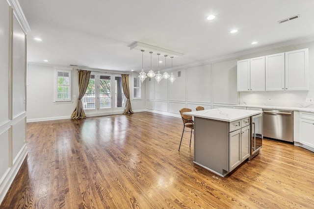 kitchen featuring a center island, dishwasher, light stone counters, and white cabinets