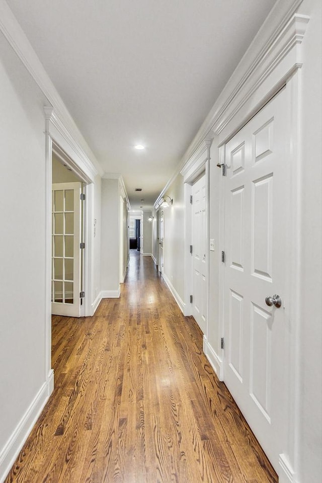 corridor featuring light hardwood / wood-style flooring and ornamental molding