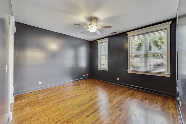 empty room with hardwood / wood-style floors and ceiling fan