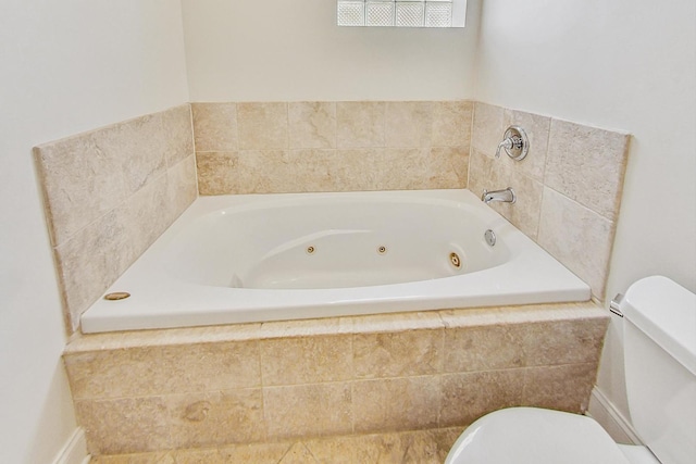 bathroom featuring toilet and tiled bath