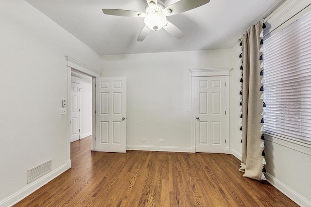 unfurnished bedroom with ceiling fan and dark hardwood / wood-style flooring