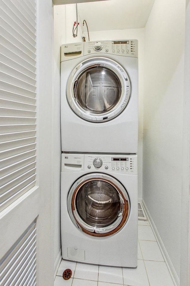 washroom featuring stacked washer / dryer and light tile patterned floors