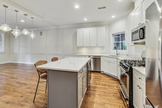 kitchen featuring a center island, white cabinets, stainless steel appliances, and hardwood / wood-style floors