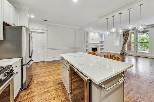 kitchen featuring a kitchen island, white cabinetry, beverage cooler, light stone counters, and light hardwood / wood-style flooring