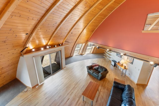 living room featuring beam ceiling, high vaulted ceiling, light hardwood / wood-style floors, and wooden ceiling