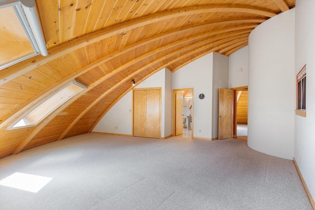 bonus room featuring lofted ceiling with skylight and wooden ceiling