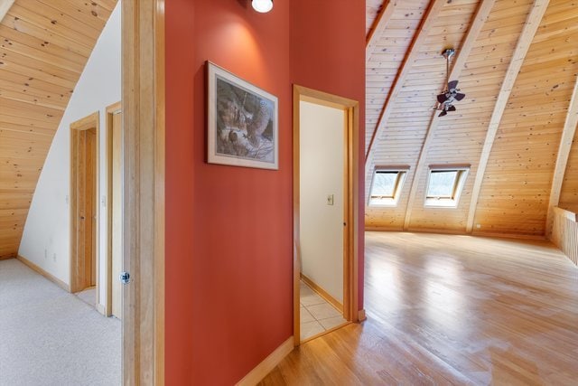 corridor featuring wood ceiling, beam ceiling, high vaulted ceiling, and light wood-type flooring