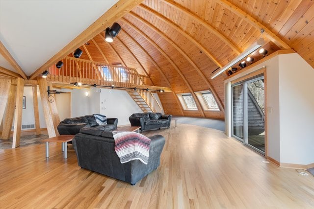 living room with high vaulted ceiling, beamed ceiling, wood-type flooring, and wooden ceiling