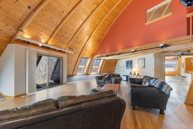 living room featuring beam ceiling, hardwood / wood-style floors, wood ceiling, and high vaulted ceiling