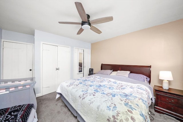 bedroom featuring multiple closets, light colored carpet, and ceiling fan