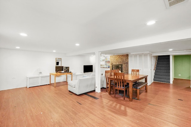 dining area featuring light hardwood / wood-style floors and a fireplace