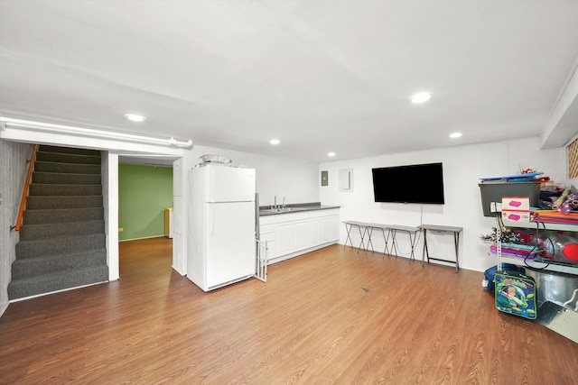 unfurnished living room with sink and wood-type flooring