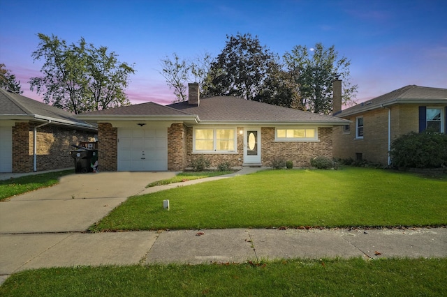 single story home featuring a yard and a garage