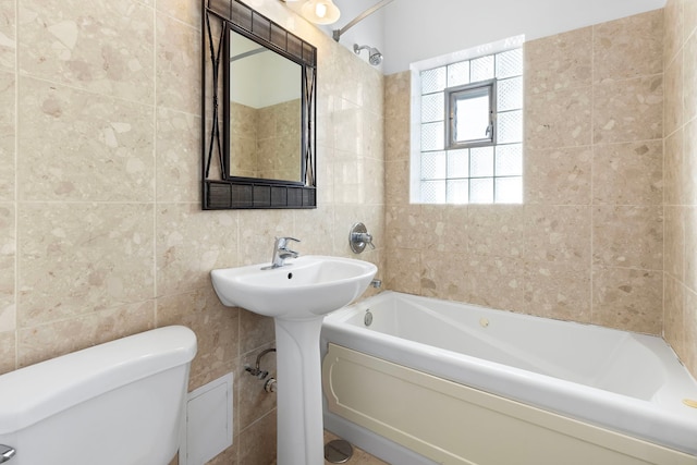 bathroom with toilet, tile walls, and a bath