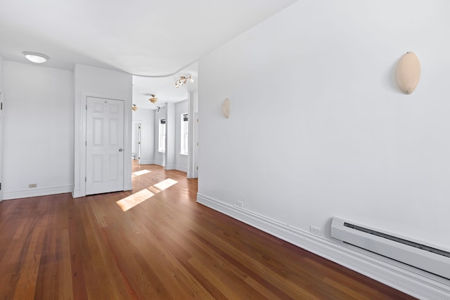 unfurnished room featuring hardwood / wood-style flooring and baseboard heating