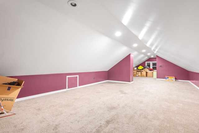 bonus room with vaulted ceiling and carpet flooring