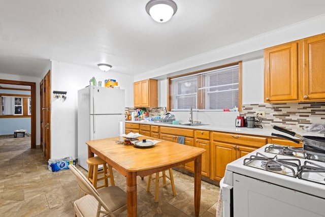 kitchen featuring sink, decorative backsplash, and white appliances