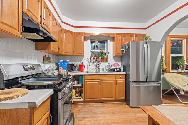 kitchen featuring light hardwood / wood-style floors, stainless steel appliances, sink, and backsplash