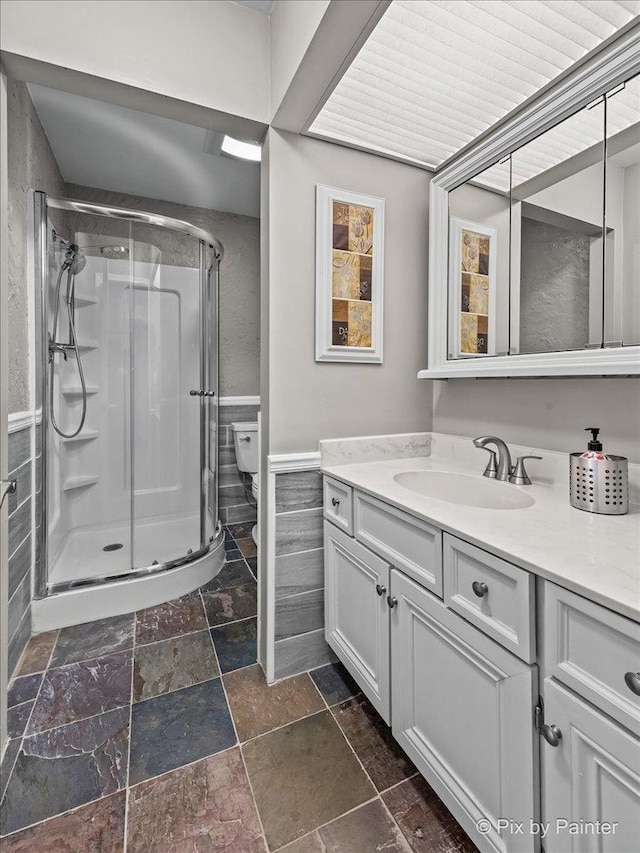 bathroom featuring walk in shower, vanity, and toilet