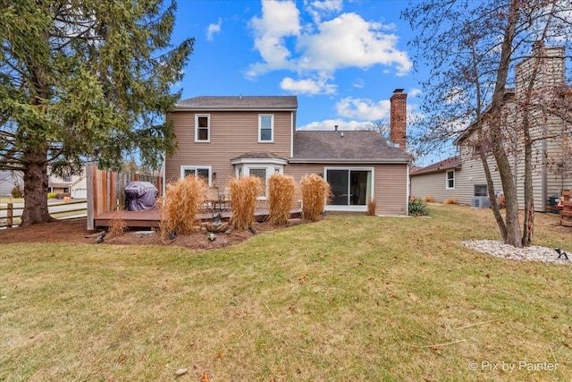 rear view of house with a wooden deck and a yard