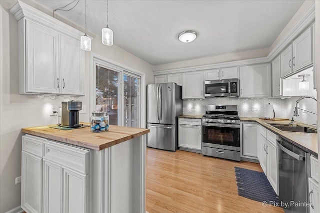 kitchen featuring butcher block countertops, sink, white cabinets, and stainless steel appliances