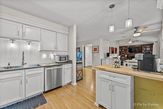 kitchen with tasteful backsplash, stainless steel dishwasher, sink, decorative light fixtures, and white cabinets