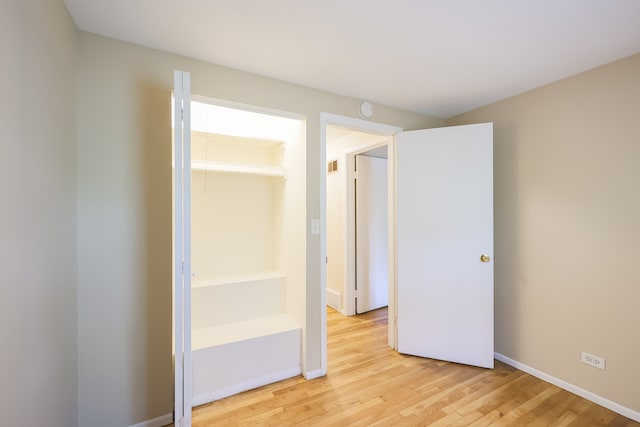 unfurnished bedroom featuring a closet and light hardwood / wood-style floors