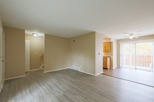 unfurnished living room with ceiling fan and light wood-type flooring