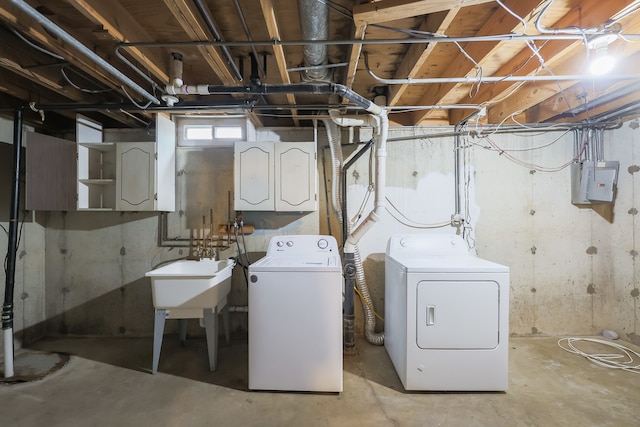 washroom featuring cabinets, sink, and washing machine and clothes dryer