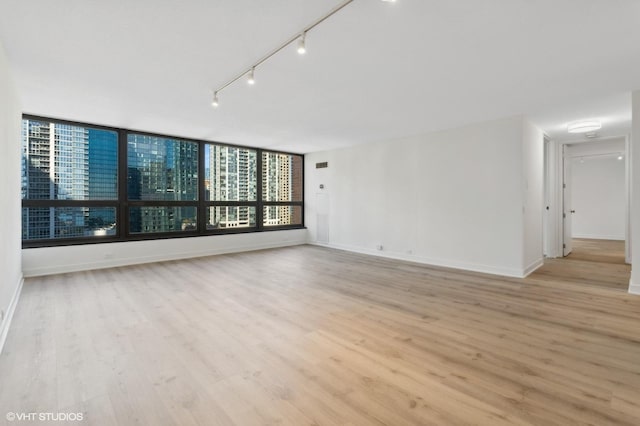 360 E Randolph St Unit 1807, Chicago, IL 60601 - spare room featuring light wood-type flooring, baseboards, and rail lighting