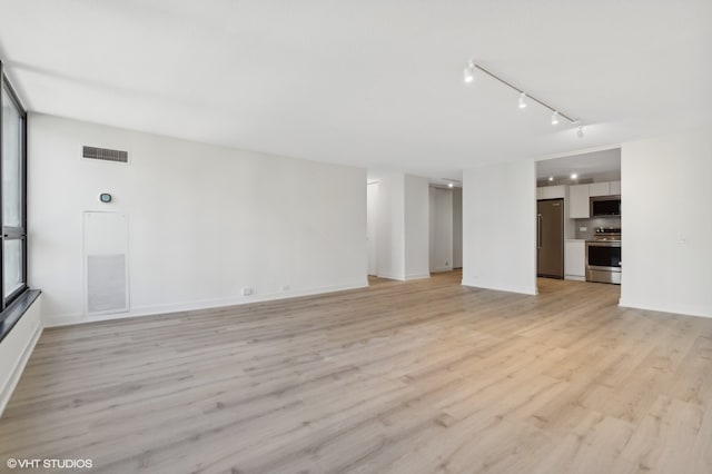 unfurnished living room with light hardwood / wood-style floors and track lighting