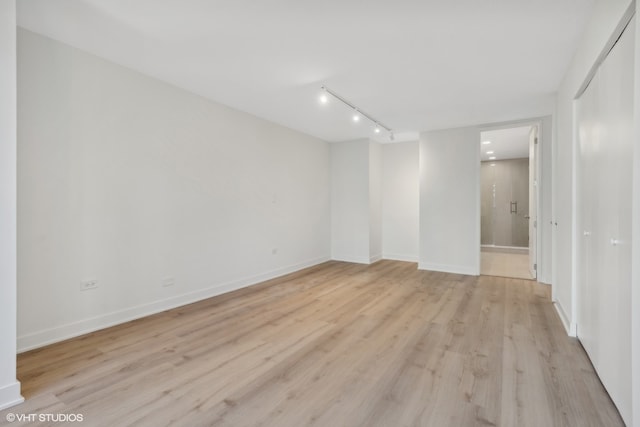 unfurnished room featuring rail lighting and light wood-type flooring