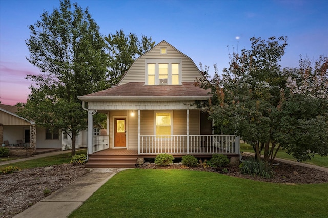 view of front facade featuring covered porch and a lawn