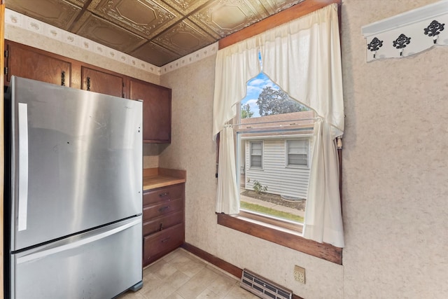 kitchen featuring coffered ceiling and stainless steel refrigerator