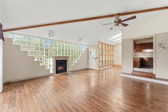 unfurnished living room with hardwood / wood-style floors, lofted ceiling with beams, and a healthy amount of sunlight