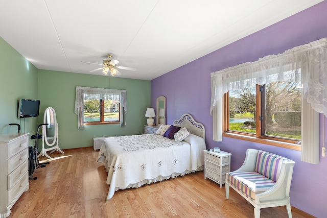 bedroom with light hardwood / wood-style floors and ceiling fan