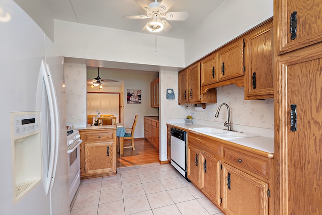 kitchen featuring hanging light fixtures, sink, light tile patterned flooring, white appliances, and ceiling fan