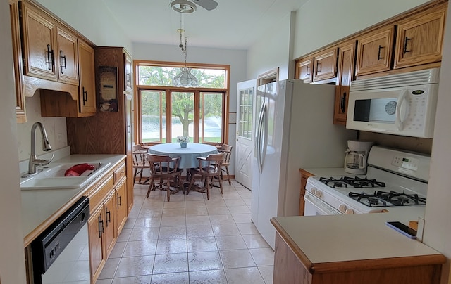 kitchen featuring white appliances, light tile patterned floors, sink, and decorative light fixtures