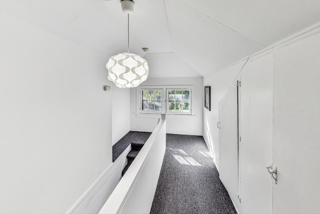 hallway featuring carpet and lofted ceiling