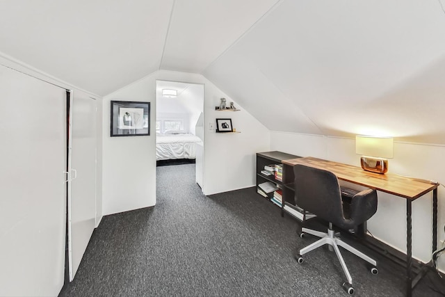 unfurnished office with lofted ceiling and dark colored carpet