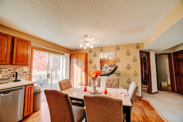 dining room featuring ceiling fan, a textured ceiling, and light hardwood / wood-style flooring