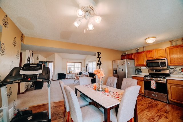 dining area with ceiling fan, a textured ceiling, and dark hardwood / wood-style floors