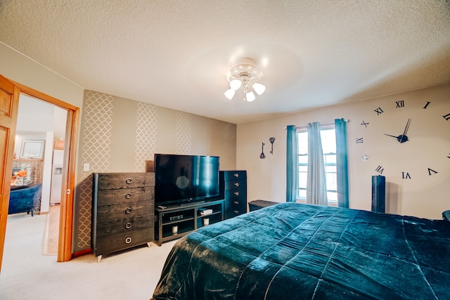 carpeted bedroom with ceiling fan and a textured ceiling