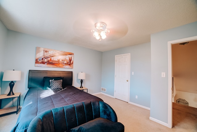 carpeted bedroom featuring a textured ceiling and ceiling fan