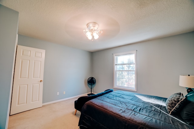 bedroom featuring ceiling fan, light carpet, and a textured ceiling