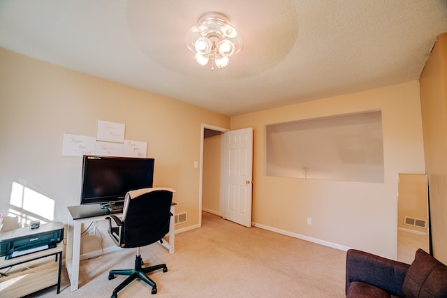 carpeted home office featuring a textured ceiling