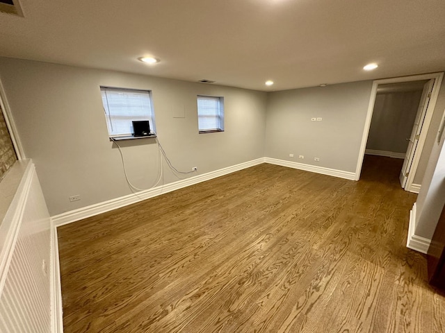 below grade area with recessed lighting, visible vents, dark wood-style flooring, and baseboards