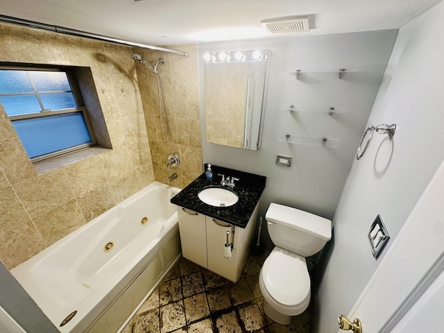 full bath featuring vanity, toilet, a combined bath / shower with jetted tub, visible vents, and stone finish floor